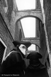 Ref VENICE 12 – Two carnival figures passing under old arches